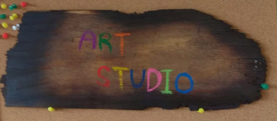 שלט עץ עם כיתוב צבעוני art studio